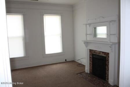 unfurnished living room featuring carpet flooring and a fireplace with flush hearth