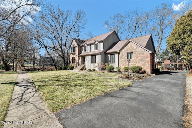 view of front of house with stone siding and a front lawn