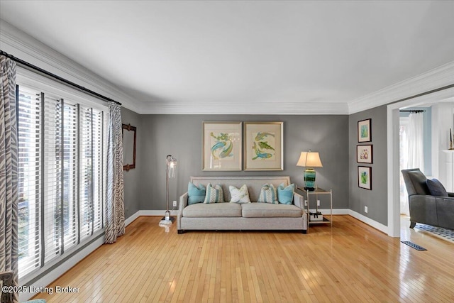 living area featuring ornamental molding, a wealth of natural light, and light wood-style floors