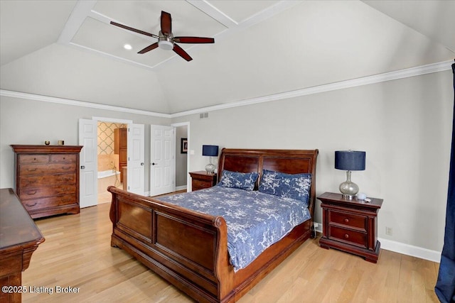 bedroom featuring lofted ceiling, ensuite bath, baseboards, and wood finished floors