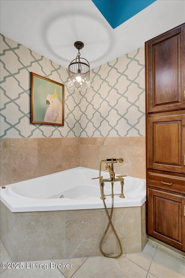 bathroom featuring a garden tub, tile patterned flooring, tile walls, and an inviting chandelier