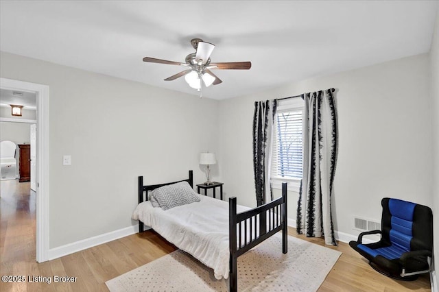 bedroom featuring light wood-type flooring, visible vents, ceiling fan, and baseboards