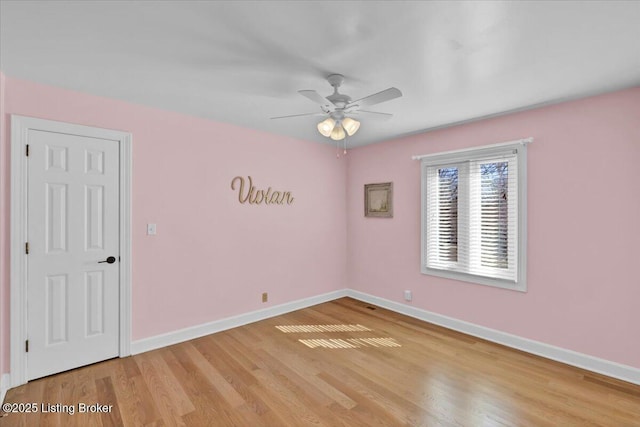 unfurnished room with light wood-type flooring, ceiling fan, and baseboards