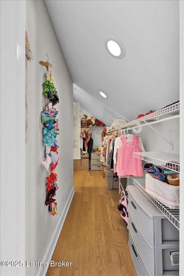 spacious closet with lofted ceiling and light wood-type flooring