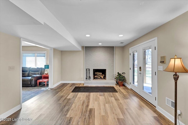 living room with a wealth of natural light, visible vents, baseboards, and wood finished floors