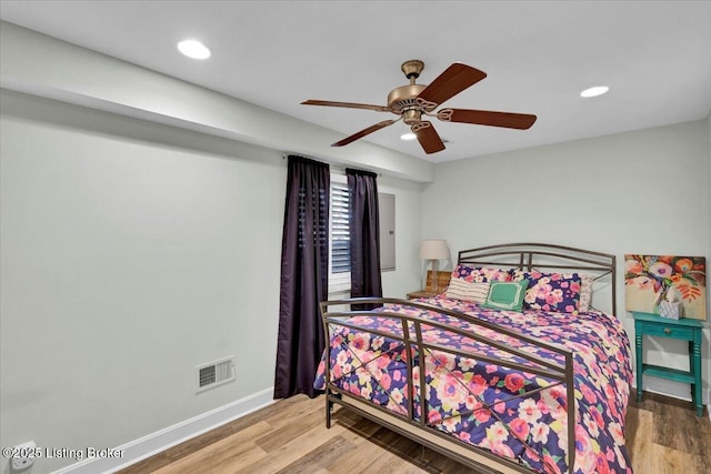 bedroom with recessed lighting, wood finished floors, visible vents, and baseboards