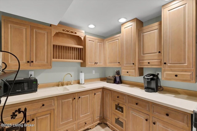 kitchen with light countertops, a sink, and recessed lighting