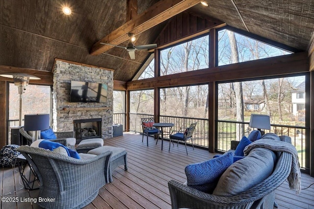 living room with beamed ceiling, an outdoor stone fireplace, high vaulted ceiling, and hardwood / wood-style flooring