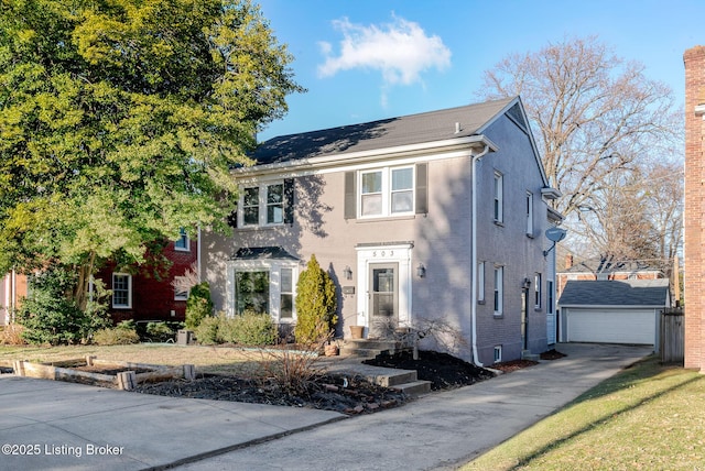 colonial inspired home featuring an outdoor structure and a detached garage