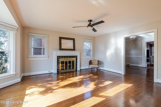 unfurnished living room with dark wood-style floors, a fireplace, and a healthy amount of sunlight