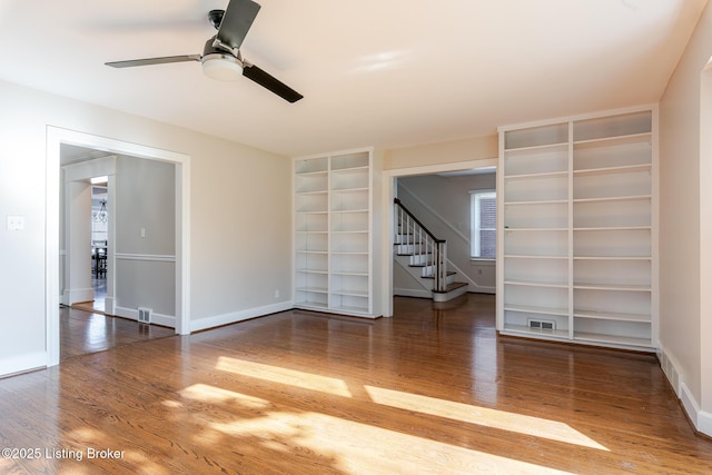 empty room with visible vents, baseboards, and wood finished floors