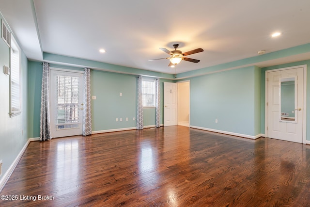 spare room with a ceiling fan, baseboards, and dark wood-type flooring