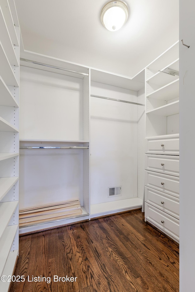 spacious closet featuring dark wood finished floors and visible vents