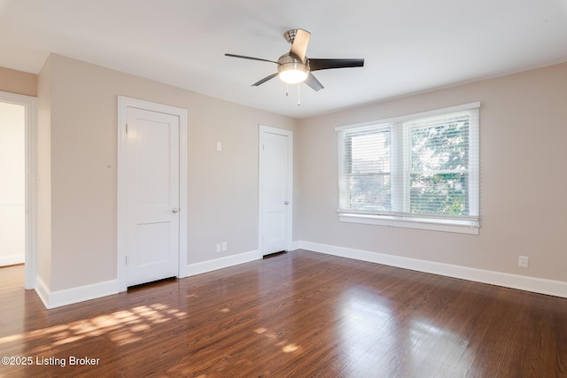 unfurnished bedroom with a ceiling fan, dark wood-style flooring, and baseboards