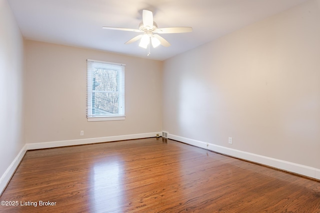 unfurnished room featuring a ceiling fan, baseboards, and wood finished floors