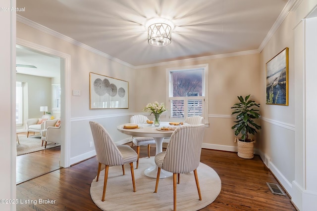 dining space featuring crown molding, visible vents, baseboards, and dark wood-type flooring