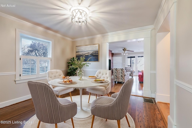 dining space featuring ornamental molding, visible vents, and wood finished floors