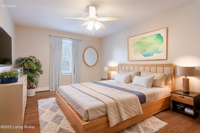 bedroom featuring a ceiling fan, baseboards, and wood finished floors