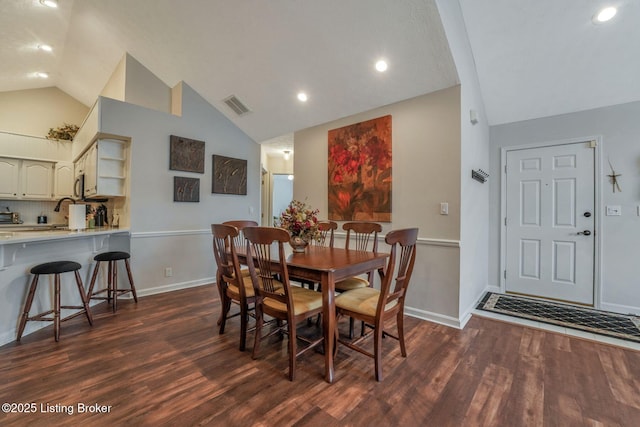 dining area featuring high vaulted ceiling, dark wood finished floors, visible vents, and baseboards