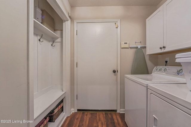 clothes washing area featuring cabinet space, separate washer and dryer, and dark wood finished floors