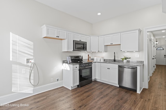 kitchen featuring appliances with stainless steel finishes, dark wood-style flooring, a sink, and white cabinetry