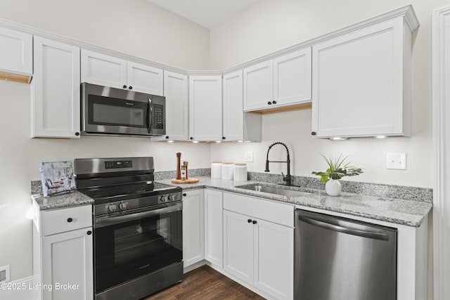 kitchen with appliances with stainless steel finishes, a sink, and white cabinets