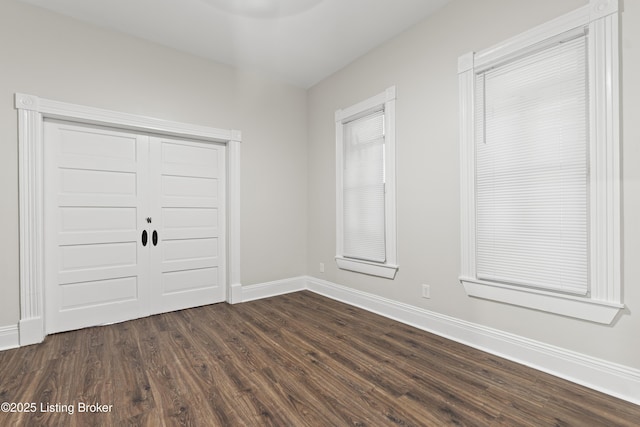 interior space featuring dark wood-type flooring and baseboards