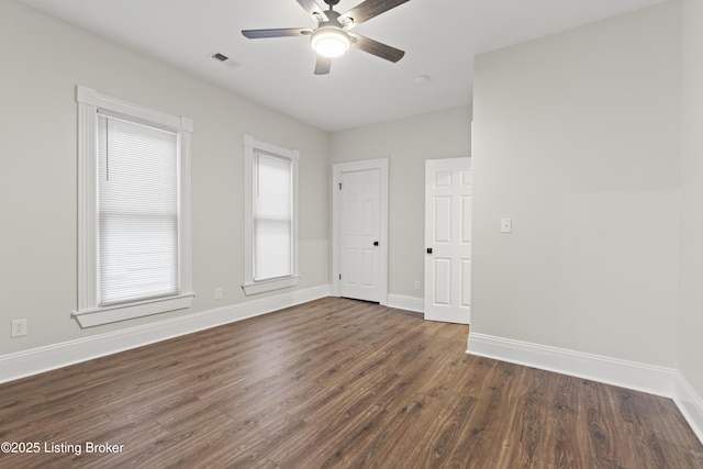 spare room with visible vents, dark wood finished floors, baseboards, and ceiling fan