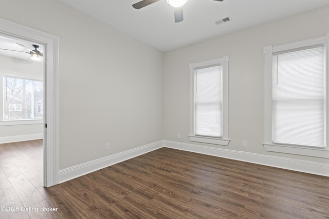 unfurnished room featuring a ceiling fan, dark wood-style flooring, visible vents, and baseboards