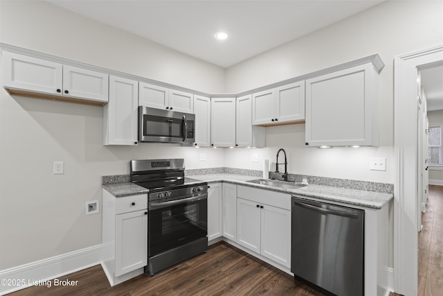 kitchen with stainless steel appliances, white cabinetry, a sink, and dark wood-style floors