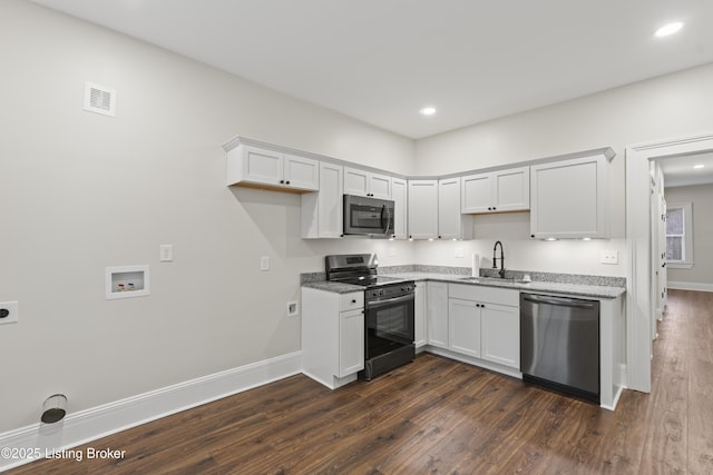 kitchen with a sink, visible vents, white cabinets, appliances with stainless steel finishes, and dark wood-style floors