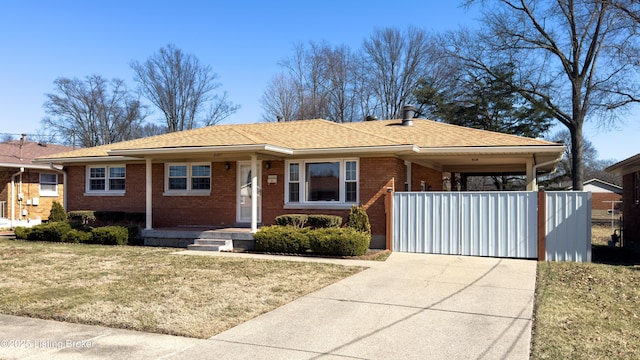 ranch-style house with an attached carport, concrete driveway, brick siding, and a front lawn