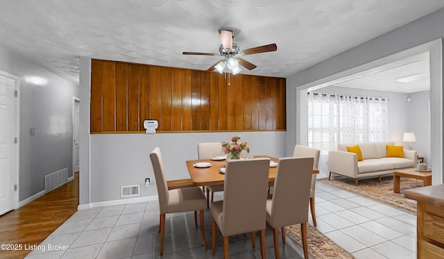 dining room featuring light tile patterned floors, ceiling fan, visible vents, and baseboards