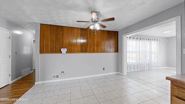 unfurnished room featuring a ceiling fan, visible vents, and light tile patterned flooring