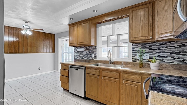 kitchen with a ceiling fan, a sink, stainless steel appliances, backsplash, and light tile patterned flooring