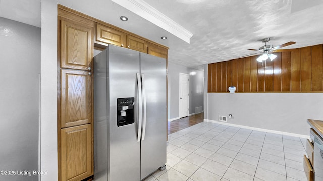 kitchen featuring light tile patterned floors, stainless steel fridge with ice dispenser, visible vents, a ceiling fan, and baseboards