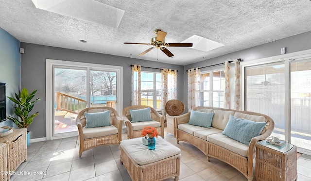 sunroom with a ceiling fan and a skylight