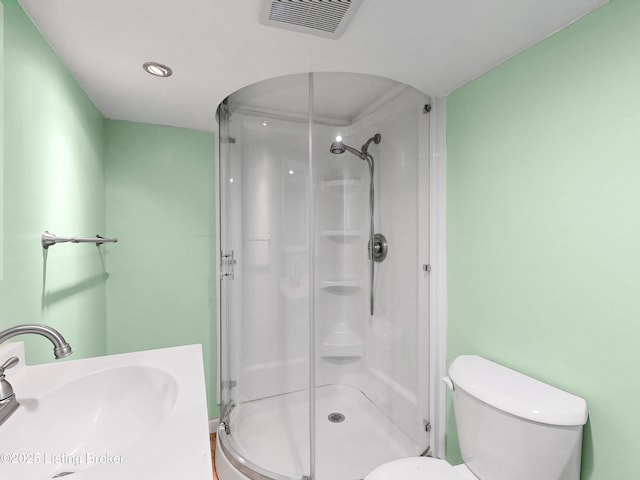 bathroom with toilet, a stall shower, visible vents, and a sink