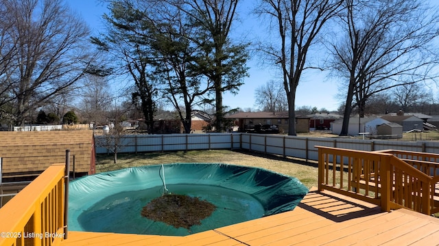 view of swimming pool featuring a hot tub, a fenced backyard, and a deck