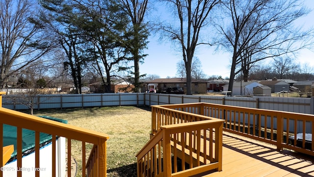 wooden terrace featuring a lawn, a fenced backyard, and a residential view