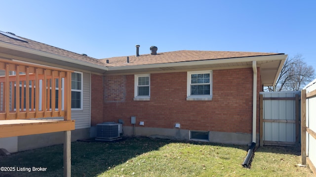 view of home's exterior with brick siding, a lawn, and central AC unit