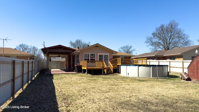 rear view of property featuring a wooden deck, a fenced backyard, a fenced in pool, and a gazebo