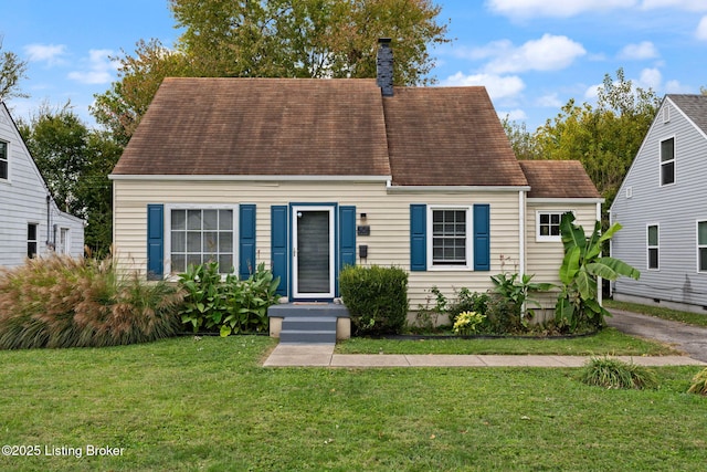 cape cod-style house with a chimney and a front yard