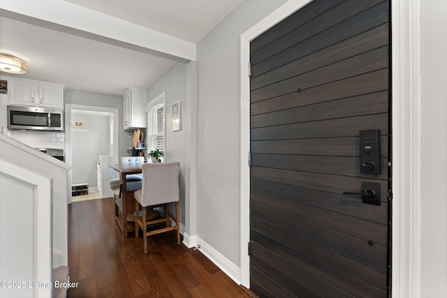 interior space featuring dark wood-type flooring and baseboards