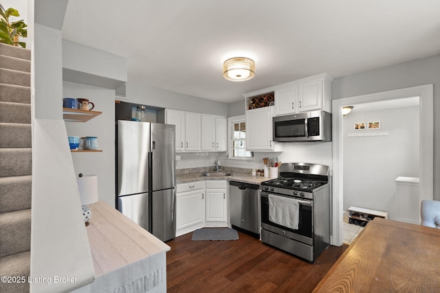 kitchen with tasteful backsplash, light countertops, appliances with stainless steel finishes, white cabinetry, and a sink