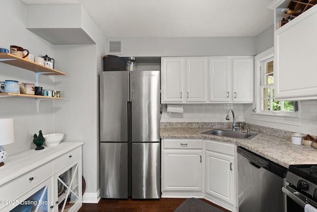 kitchen featuring light countertops, appliances with stainless steel finishes, a sink, and white cabinets