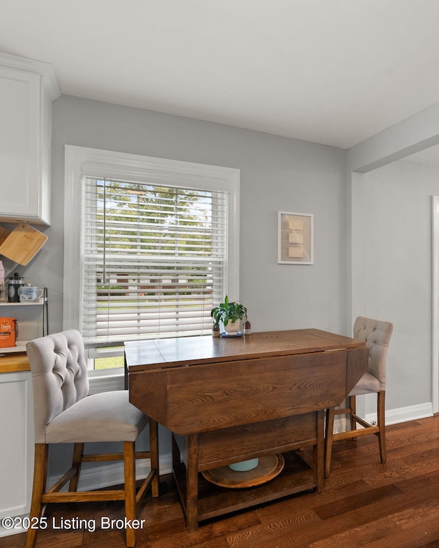 dining room with baseboards and dark wood finished floors