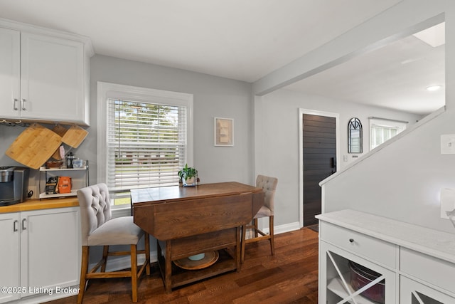 dining space featuring plenty of natural light, dark wood finished floors, and baseboards