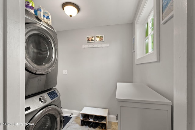 laundry room with stacked washer / drying machine, laundry area, and baseboards