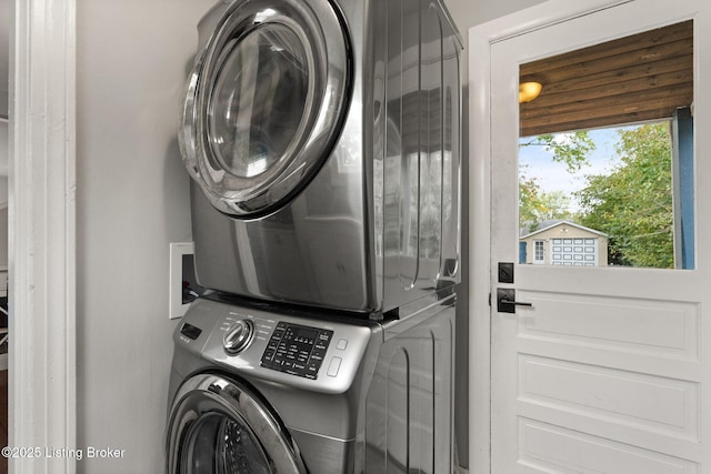 clothes washing area featuring laundry area and stacked washing maching and dryer